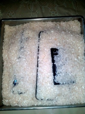 A smartphone being buried in rice to dry it out.