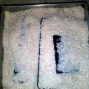 A smartphone being buried in rice to dry it out.