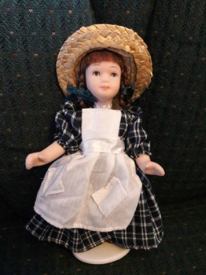 Doll Identification and Value - doll wearing straw hat and plaid dress with bib apron