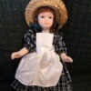 Doll Identification and Value - doll wearing straw hat and plaid dress with bib apron