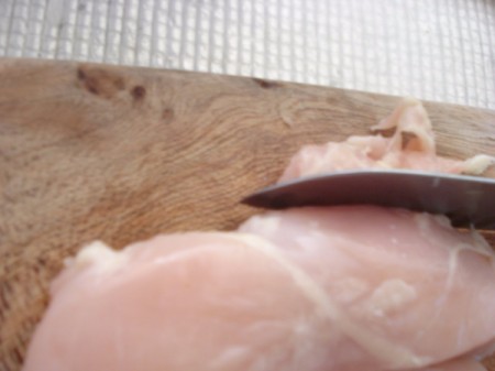 cutting raw chicken