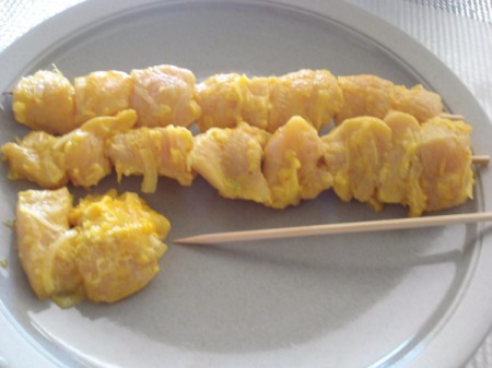 putting chicken on skewers