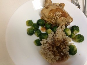 A plate of simmered chicken with rice and vegetables.