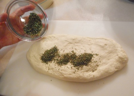 Adding herbs to bread dough.