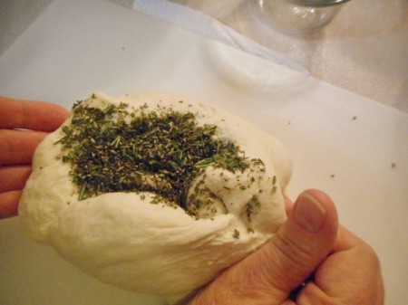 Adding herbs to bread dough.