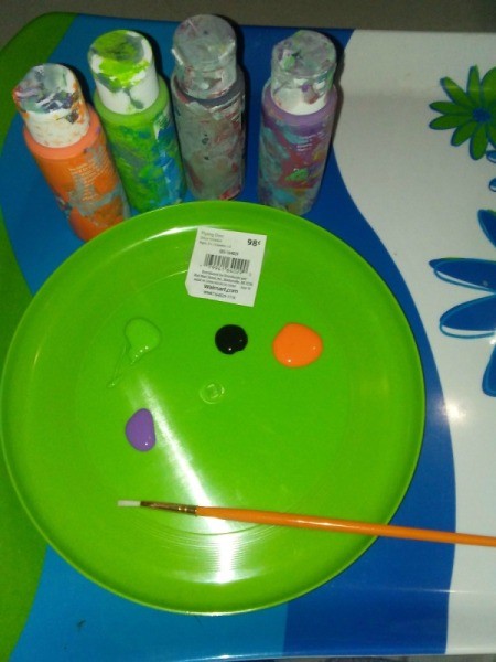 A frisbee being used as a paint palette.