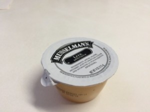 A small serving sized container of applesauce.