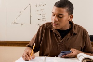 A young man studying for his math class.