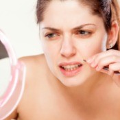 A woman removing hair from her upper lip.