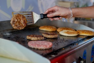 Greasy burgers being cooked at a fast food restaurant.