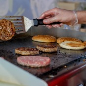 Greasy burgers being cooked at a fast food restaurant.