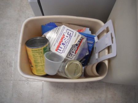 A trash can full of recycling.