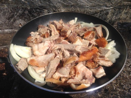 Adding pork to the stir fry pan.