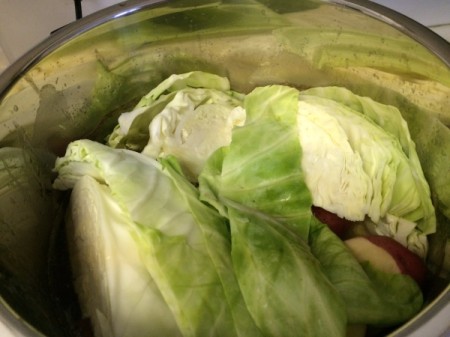 A pressure cooker with corned beef and cabbage inside.