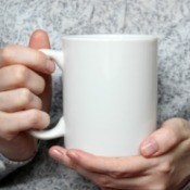 A woman holding a blank coffee cup.