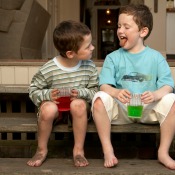 Two boys drinking koolaid outside.