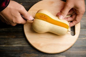 A butternut squash being cut in half.