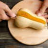 A butternut squash being cut in half.