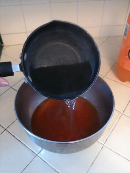 adding boiling water to jello in bowl.