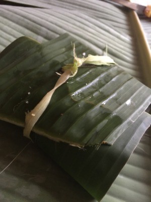 wrapped small fish in tied  banana leaf