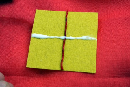 Birthday Parcel Card - apply glue to stick on bow, across the first piece of cord