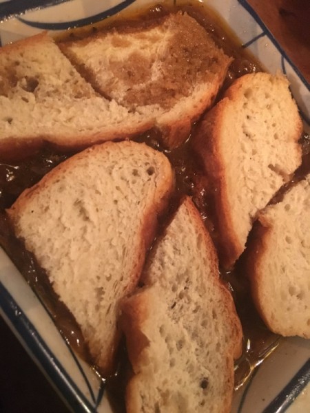 adding bread sliced to broth in pan for French onion soup.