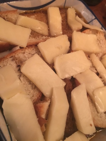 cheese slices on bread in pan for French onion soup.