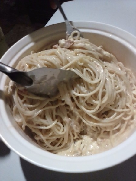 mixing sauce with noodles