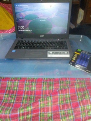 A laptop computer with a storage container lid underneath it.