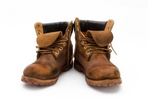 A pair of well worn work boots, on a white background.