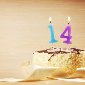 Birthday cake with burning number fourteen candle