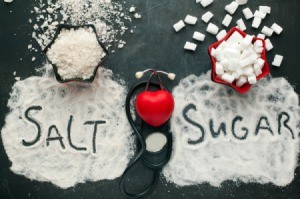 Salt and sugar spilled on a black table.