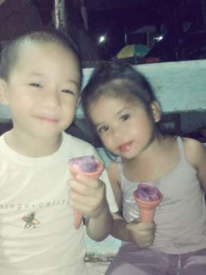 Two children eating ice cream cones.