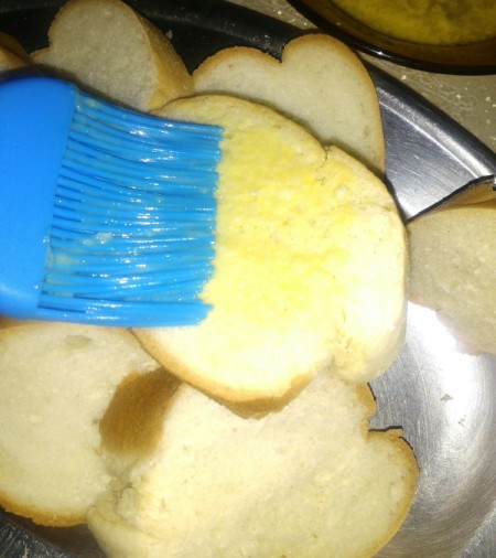 brushing bread with garlic butter