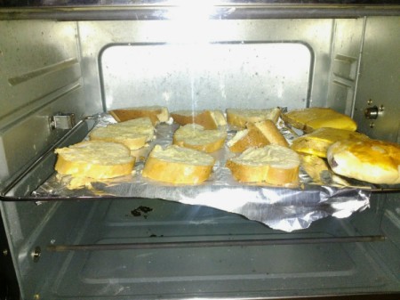 garlic bread pieces on foil lined pan in oven