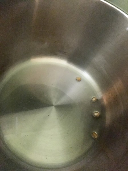 a few kernels of popcorn in their in pan