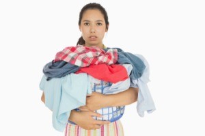 A woman holding a basket full of laundry.