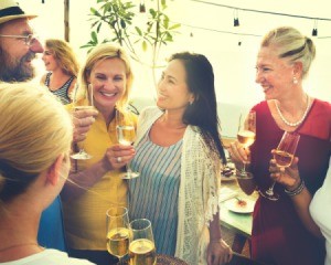 Group of adults at a party drinking wine.