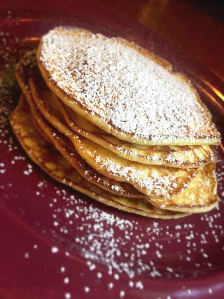 Mini Cream Cheese Crepes on plate and sprinkled with powdered sugar