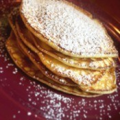 Mini Cream Cheese Crepes on plate and sprinkled with powdered sugar