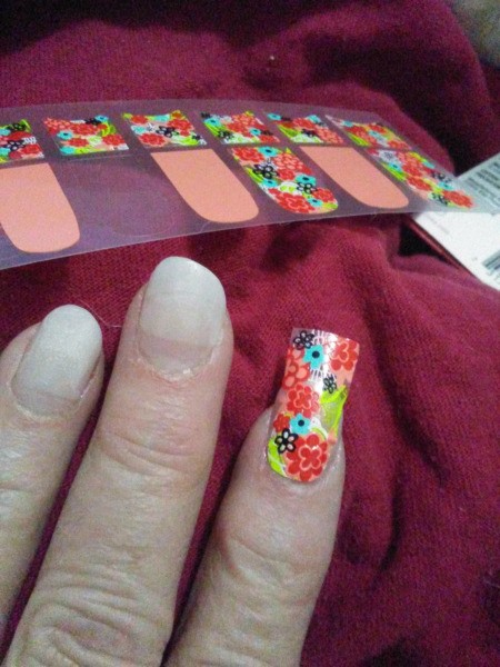 Placing nail decals on acrylic nails.