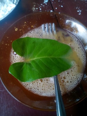 dipping water spinach leaf in beaten egg