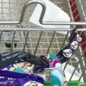 A purse attached to a shopping cart with the child straps.