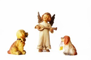 An angel figurine with two dog figurines.