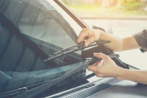 A person adjusting a car's windshield wiper.