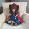 Value of a Porcelain Doll - doll wearing a red and blue pinafore dress and hat