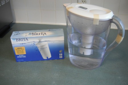 A Brita water filter pitcher with freezer tape holding the lid in place.