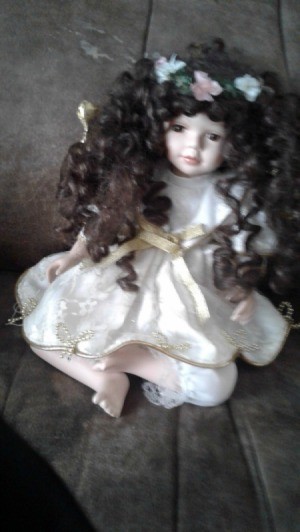 Value of Porcelain Doll - doll with long curly hair wearing a flower wreath