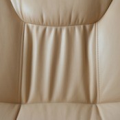 Back of a tan colored faux leather chair.