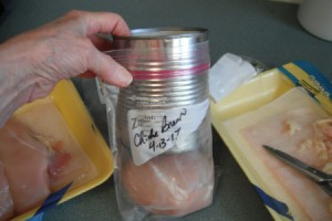 A large can being used to fill a freezer bag.